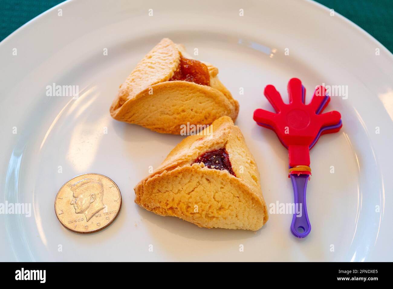 Nahaufnahme eines Tellers mit amerikanischen Halbdollar-, grogger- und Hamantaschen-Keksen, rituellen Gegenständen während des jüdischen Feiertags von Purim, Lafayette, Kalifornien, 26. Februar 2021. () Stockfoto