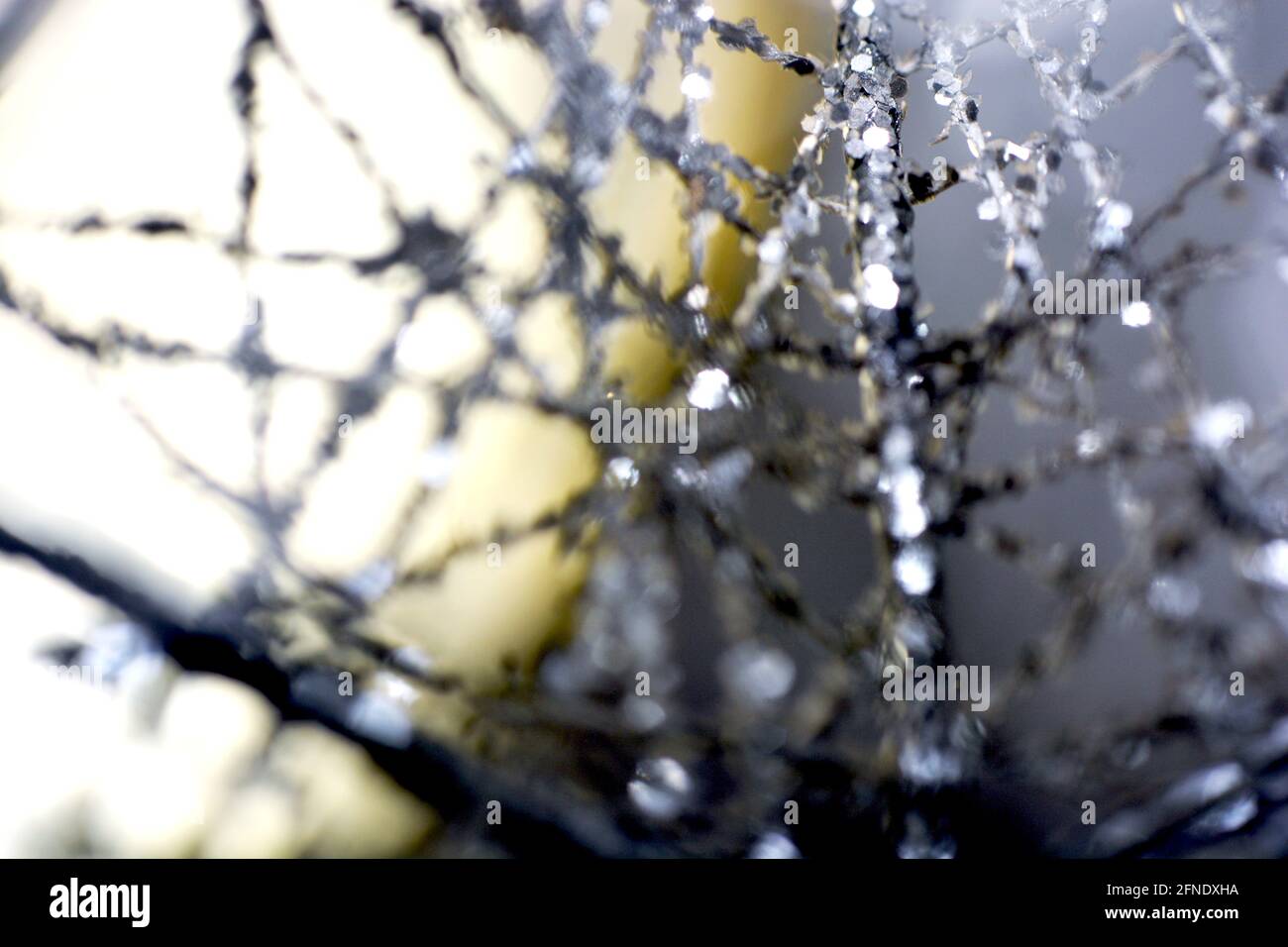 Nahaufnahme einer verschwommenen silbernen Wellenfäden auf einem unscharfen Hintergrund mit abstrakten Bokeh-Lichtern Stockfoto