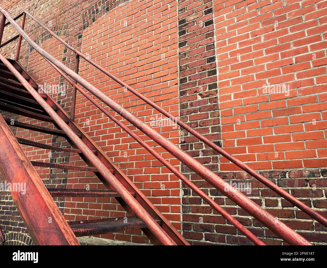Hinter der Gasse Treppen rostend gegen eine Retro verwitterte Alterung Gebäude des Backsteinlagerhauses Stockfoto