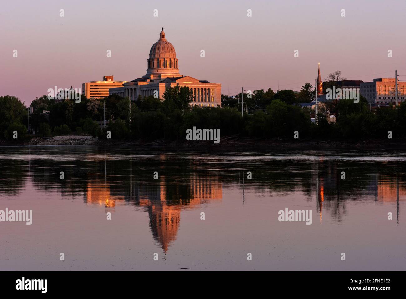 Das Missouri State Capitol in Jefferson City spiegelt sich im Missouri River bei Sonnenuntergang am 13. Mai 2021 wider. Stockfoto