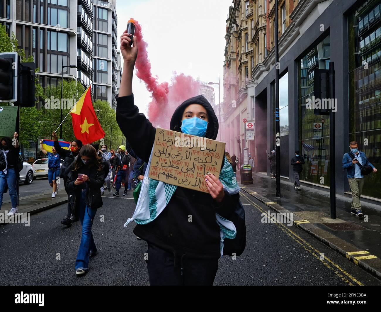 London, Großbritannien 15/05/21 EINE Frau marschiert mit einer roten Rauchbombe auf einer pro-palästinensischen Demonstration. Stockfoto