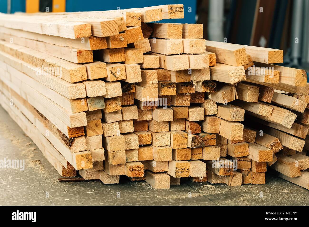 Holzbalken liegen auf dem Boden in einer Tischlerei oder einem Sägewerk. Hintergrund für einen Hersteller von Baustoffen aus Holz. Stockfoto
