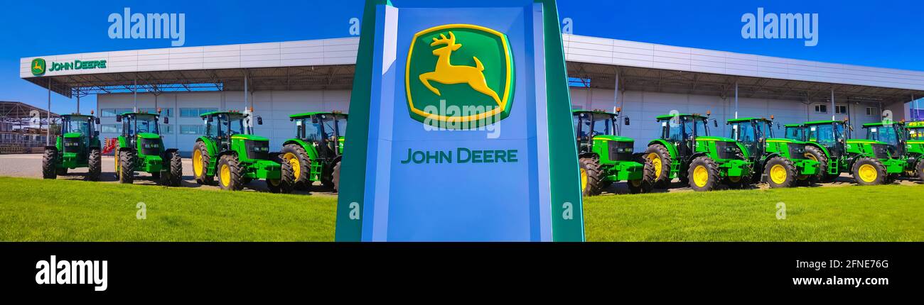 Kiew, Ukraine - 24. August 2020: Die leistungsstarken Traktoren im John Deer-Geschäft in Kiew, Ukraine, am 16. Juni 2020. Reihe brandneuer John Deere-Traktoren vor dem Laden des örtlichen Konsortiums, Ausstellung der neuesten landwirtschaftlichen Maschinen. Stockfoto