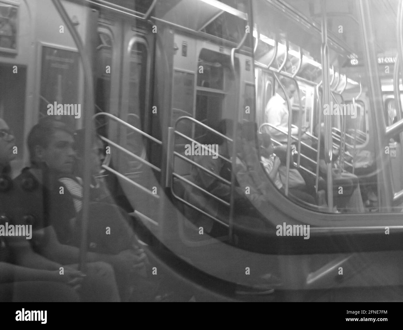 Wackelte Fahrer in zwei Waggons in einem New Yorker U-Bahn-Zug, schaute durch Glas zu Wagen vor und reflektierte die Menschen hinter dem Fotografen Stockfoto