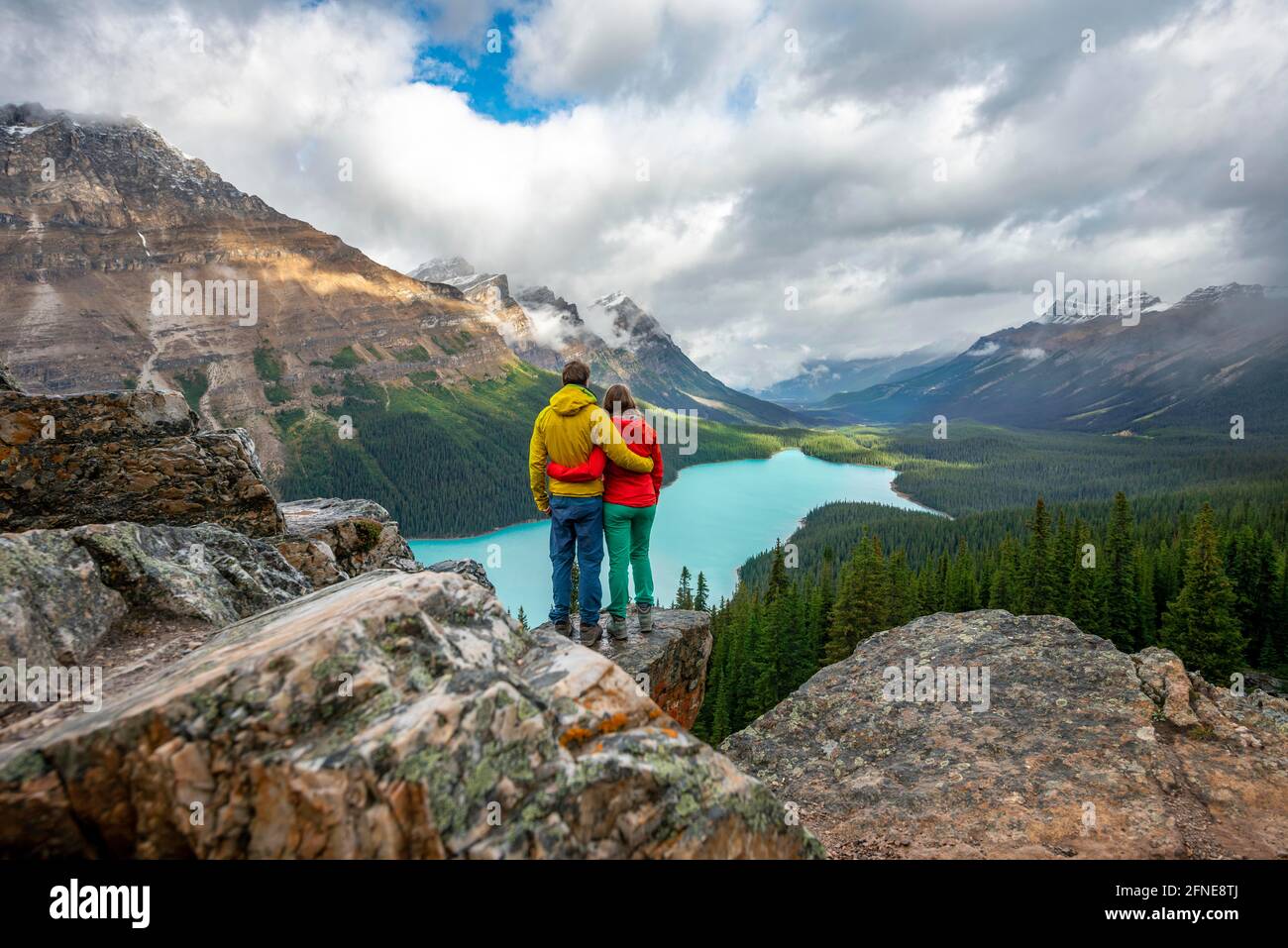 Paar umarmen, Blick in die Ferne, Blick auf türkisfarbenen Gletschersee umgeben von Wald, Peyto Lake, Rocky Mountains, Banff National Park Stockfoto