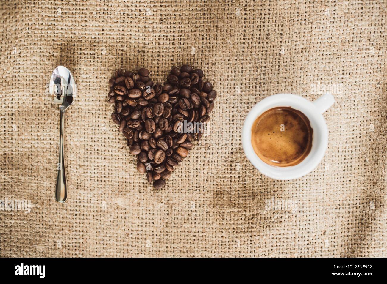 Kaffeelöffel, Herz von Kaffeebohnen und Kaffeetasse, ich liebe Kaffee Stockfoto