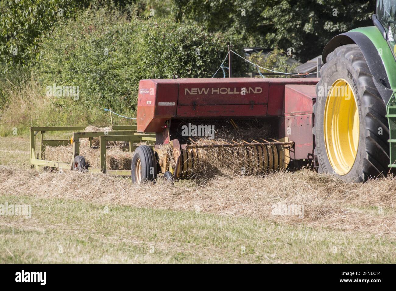 Heubereitung, dritte Stufe, Zugkraft des Traktors mit herkömmlicher Ballenpresse und Ballenwagen Stockfoto