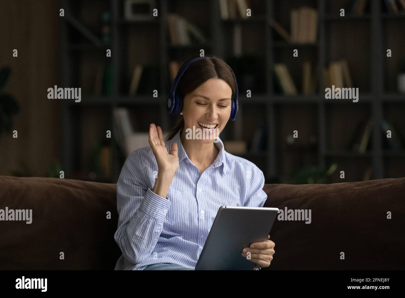 Junge Frau im Headset, die mit einem digitalen Tablet Videoclips macht Stockfoto