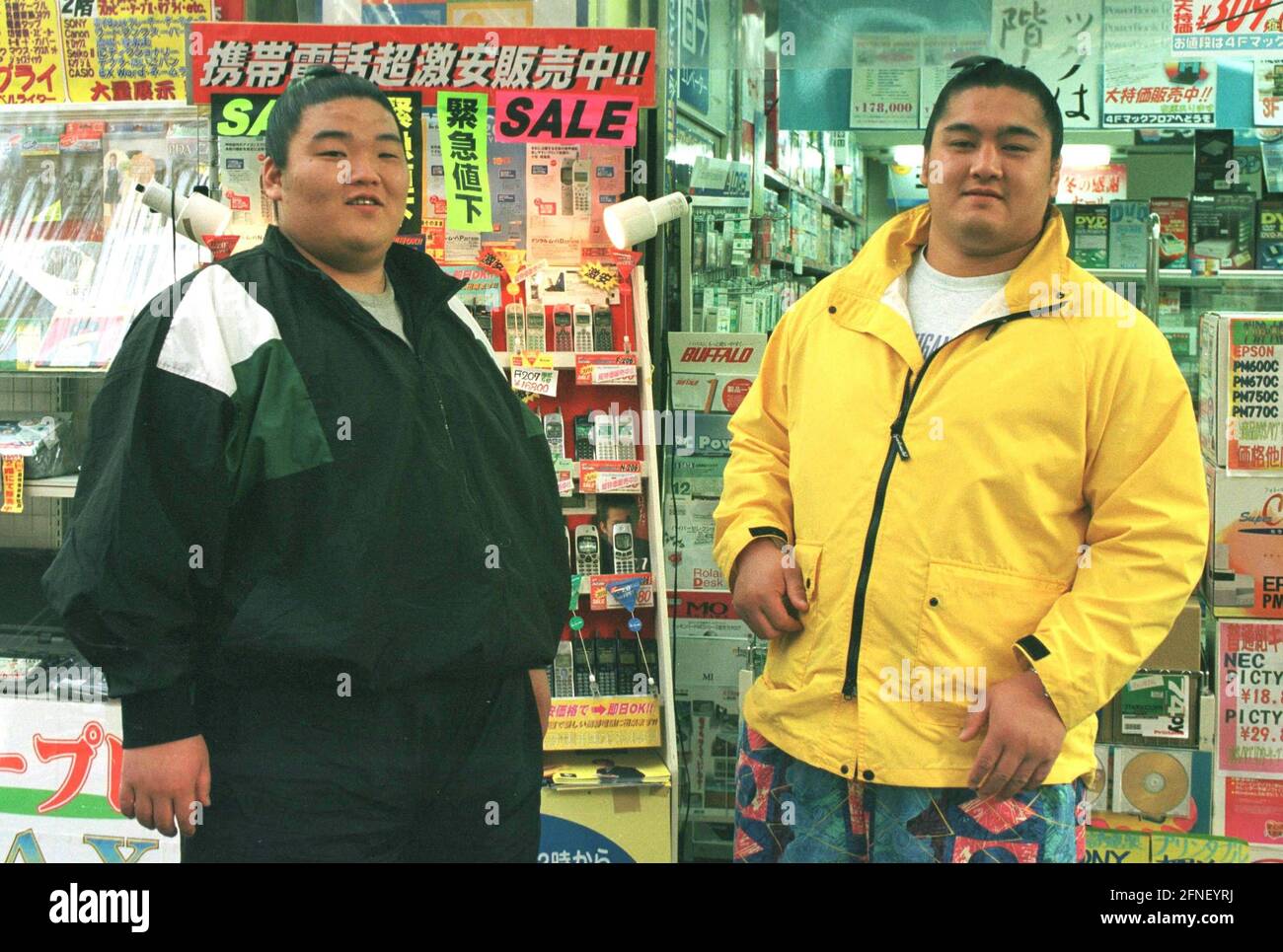 Tokyos Stadtteil Akihabara ('Eletric City') ist das Mekka der Elektronik in der japanischen Hauptstadt. Zwei Sumo-Wrestler vor einem Regal mit Mobiltelefonen im Sonderangebot. [Automatisierte Übersetzung] Stockfoto