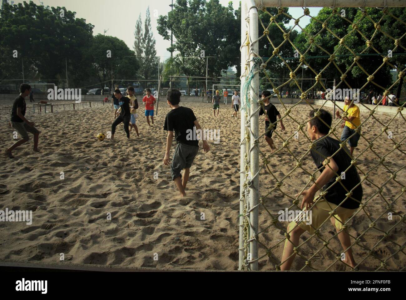 Junge Männer spielen Strandfußball (Strandfußball, Sandfußball, Beasal) im Senayan Sports Complex (Gelora Bung Karno) in Jakarta, Indonesien. Stockfoto