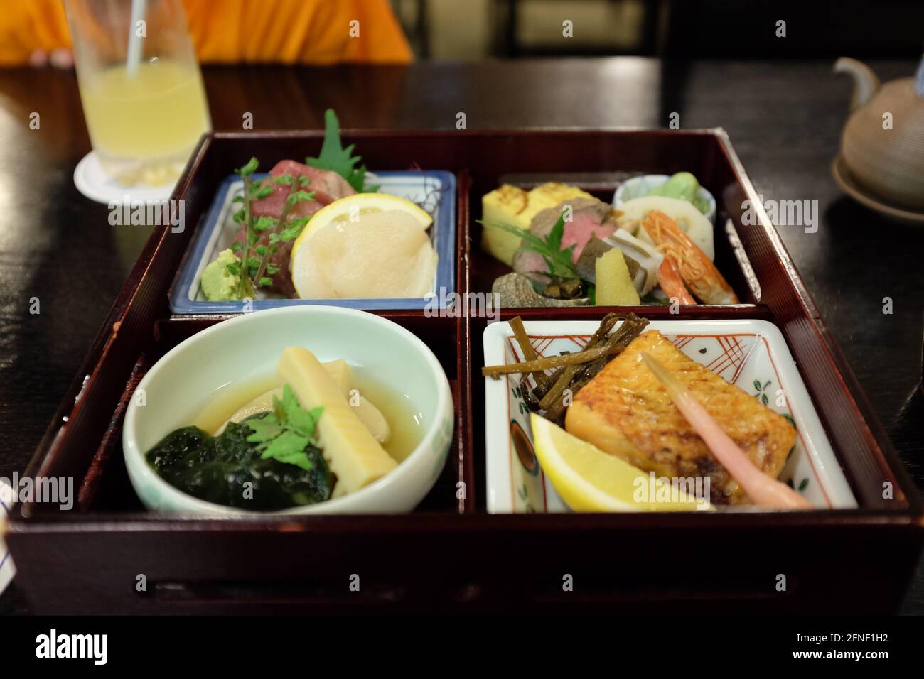 Bento-Box mit Sashimi und verschiedenen Beilagen in einem Restaurant in Tokio, Japan Stockfoto