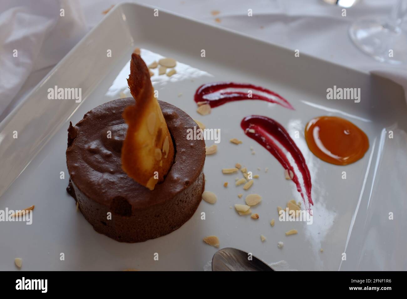 Schokoladenmousse-Dessert mit Himbeer-Coulis und Karamell an der Seite in Toulouse, Haute-Garonne, Occitanie, Südfrankreich Stockfoto