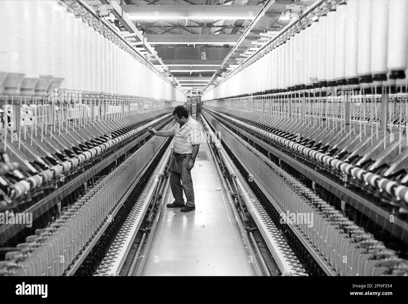 Produktion von Garnen in der Baumwollspinnerei Gronau. Arbeiter im Rotor-/ und Ringspinnen. [Automatisierte Übersetzung] Stockfoto