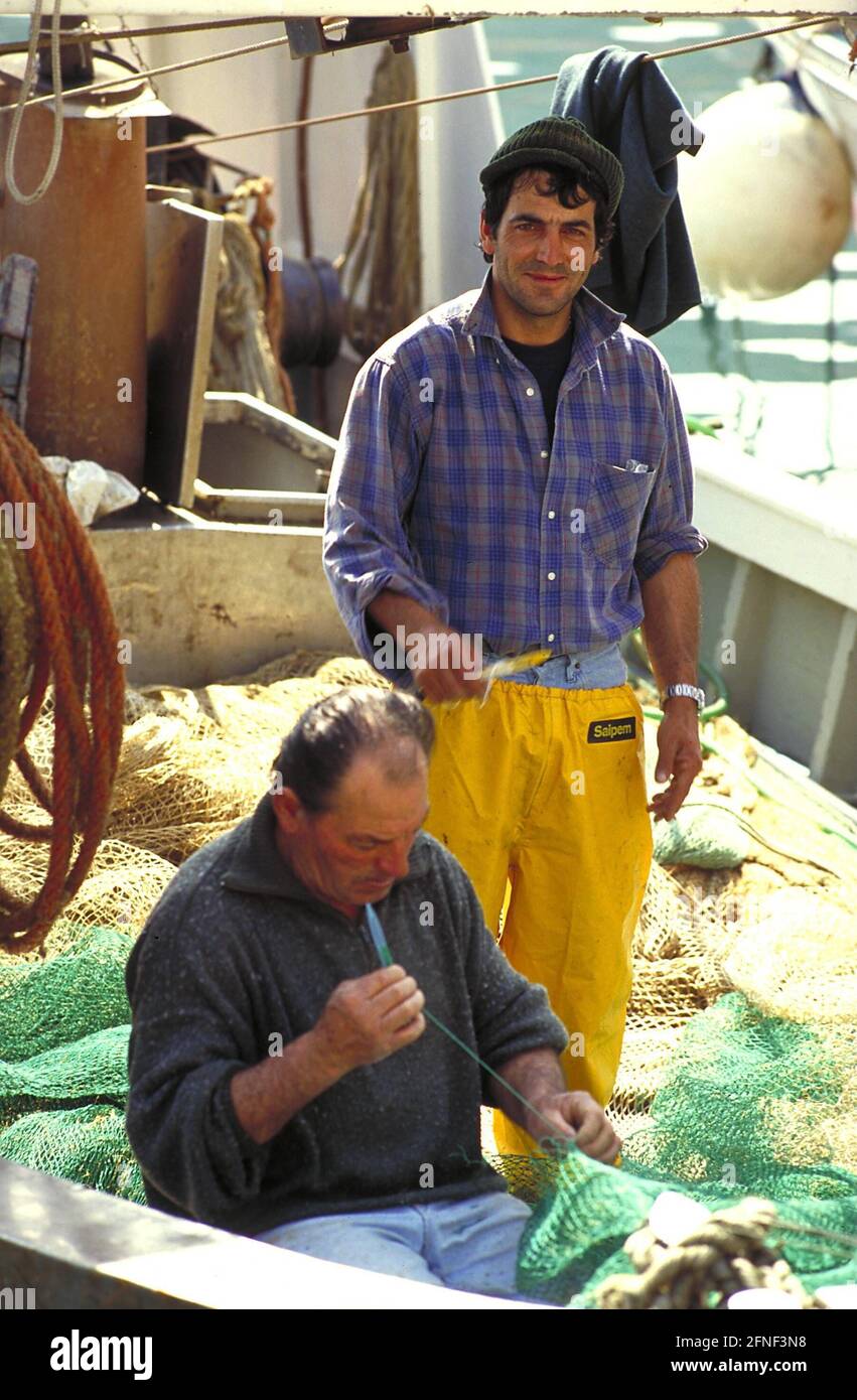 Fischer flicken sein Netz in einem Fischerboot des Hafens von S. Stefano. [Automatisierte Übersetzung] Stockfoto