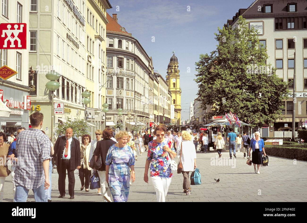 Die Theatinerstraße in der Münchner Innenstadt mit Spaziergängern. Im Hintergrund die Theatinerkirche. [Automatisierte Übersetzung] Stockfoto