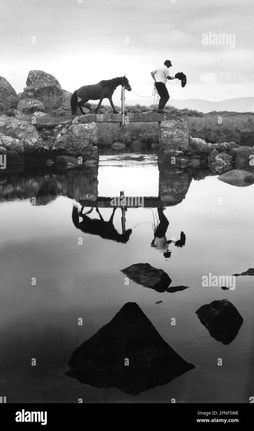 Stimmungsvolles Bild der Hochmoorlandschaft von Connemara in Irland. Durch die vielen kleinen Seen und Wasserstraßen stehen oft viele kleine Stege zum Überbrücken zur Verfügung. [Automatisierte Übersetzung] Stockfoto