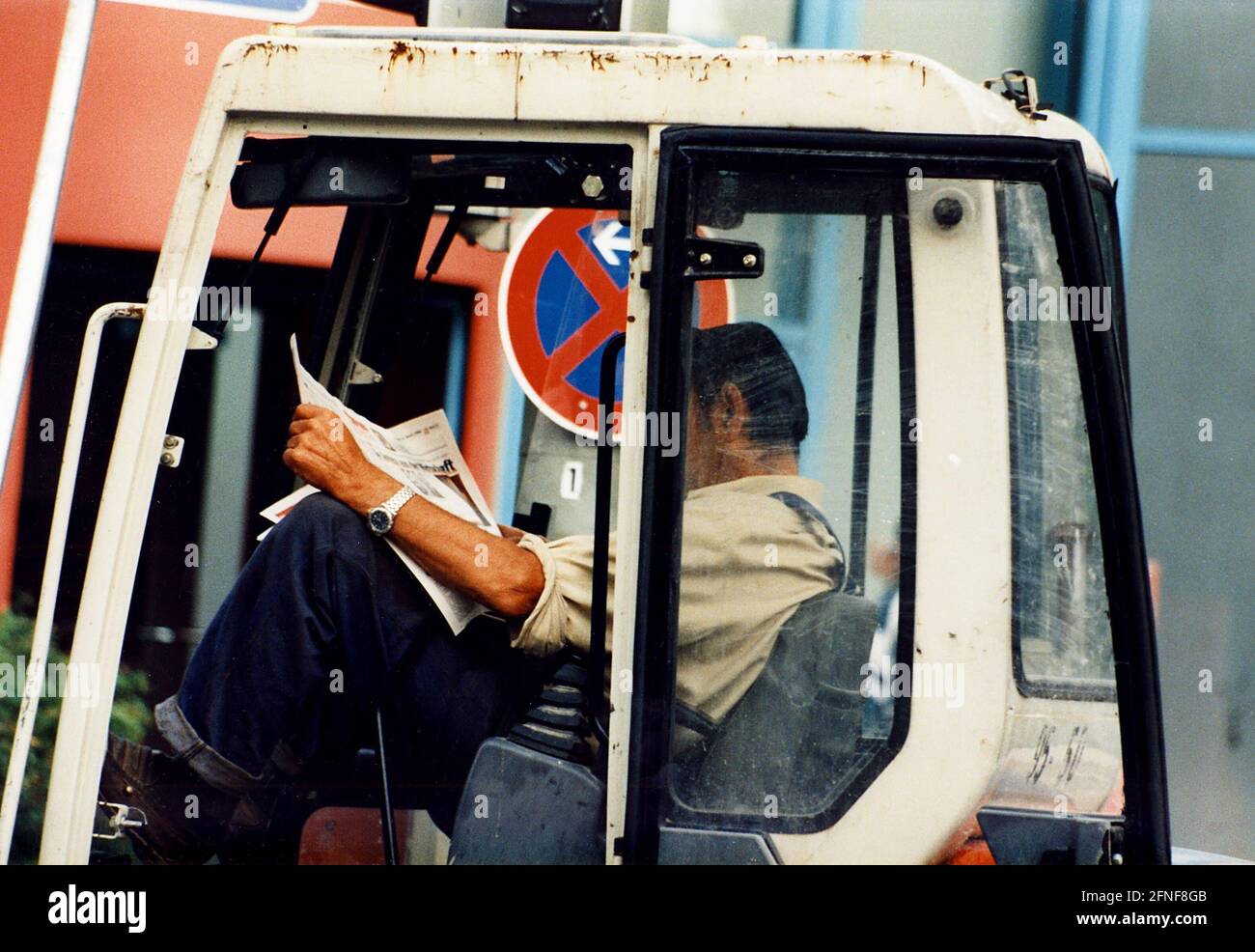 Bauarbeiter in der Kabine eines Baufahrzeugs macht eine Pause von der Arbeit. [Automatisierte Übersetzung] Stockfoto