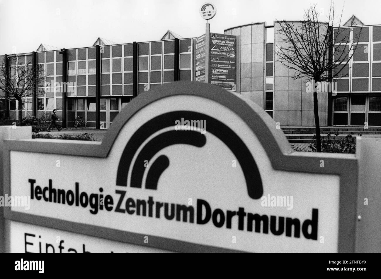 Ansicht eines Gebäudes des Dortmunder Technologiezentrums in der Nähe der Universität im Februar 1992. Im Vordergrund das Gebäudeschild. Auf dem Gebäude ein Schild mit Firmennamen und Logo. [Automatisierte Übersetzung] Stockfoto