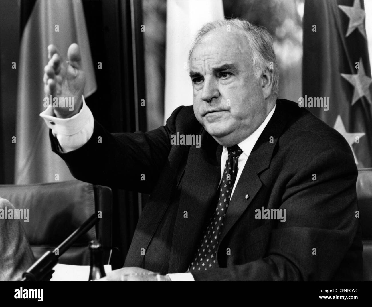 Bundeskanzler Helmut Kohl (CDU) im Porträt, gestikulierend. Im Hintergrund links die Nationalflagge der Bundesrepublik Deutschland, rechts die Europaflagge. [Automatisierte Übersetzung] Stockfoto