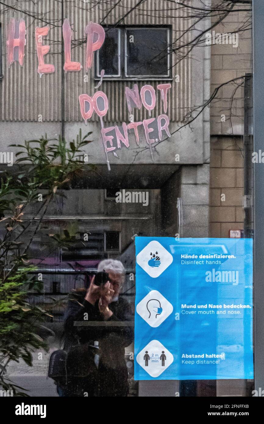 Frau, die die Hilfe fotografiert Bitte geben Sie keine graffitti- und Covid-Sicherheitsanweisungen zum Bauen in Mitte, Berlin Stockfoto