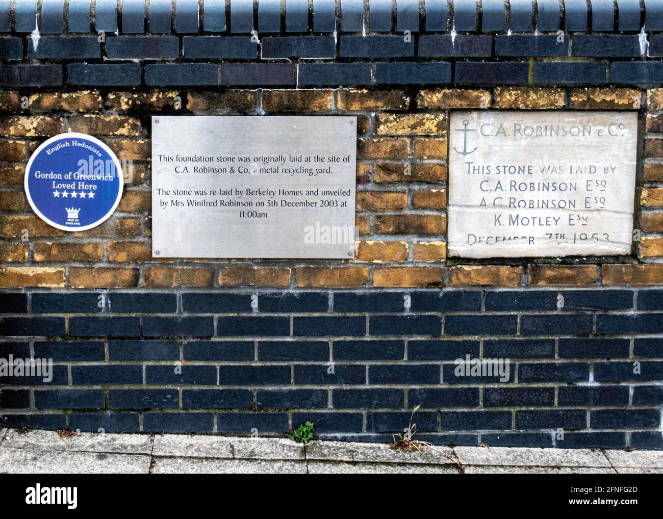 Gedenktafeln am Ballast Quay, Greenwich, SE London, Großbritannien. C EINE Robinson Metall-Recycling-Firma & humorvolle hedonistische Plakette Stockfoto