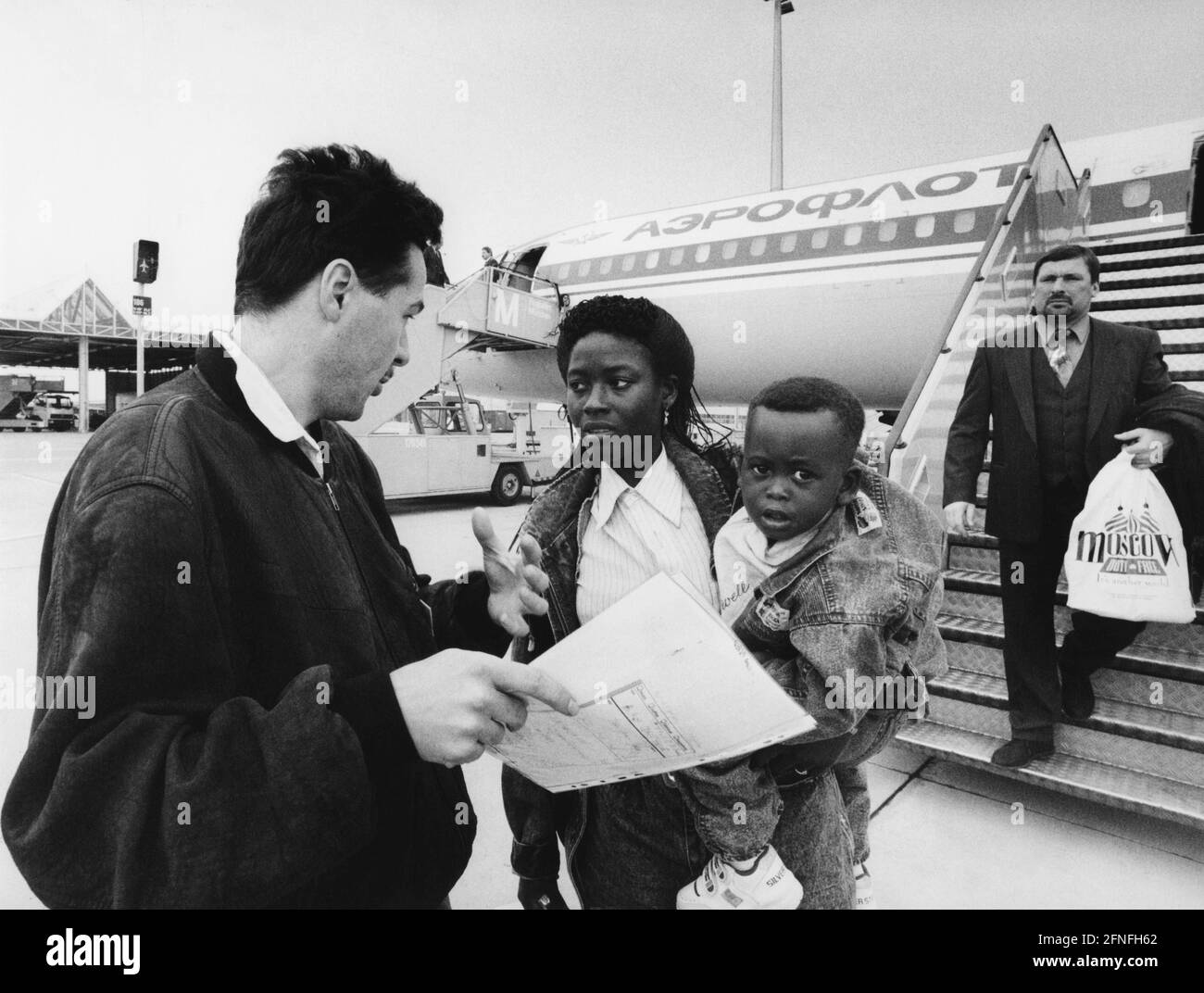 Mitglieder der Sozialdienste empfangen Flüchtlinge aus Togo am Franz-Josef-Strauß-Flughafen München, die mit einem Aeroflot-Flugzeug aus Moskau angekommen waren. [Automatisierte Übersetzung] Stockfoto