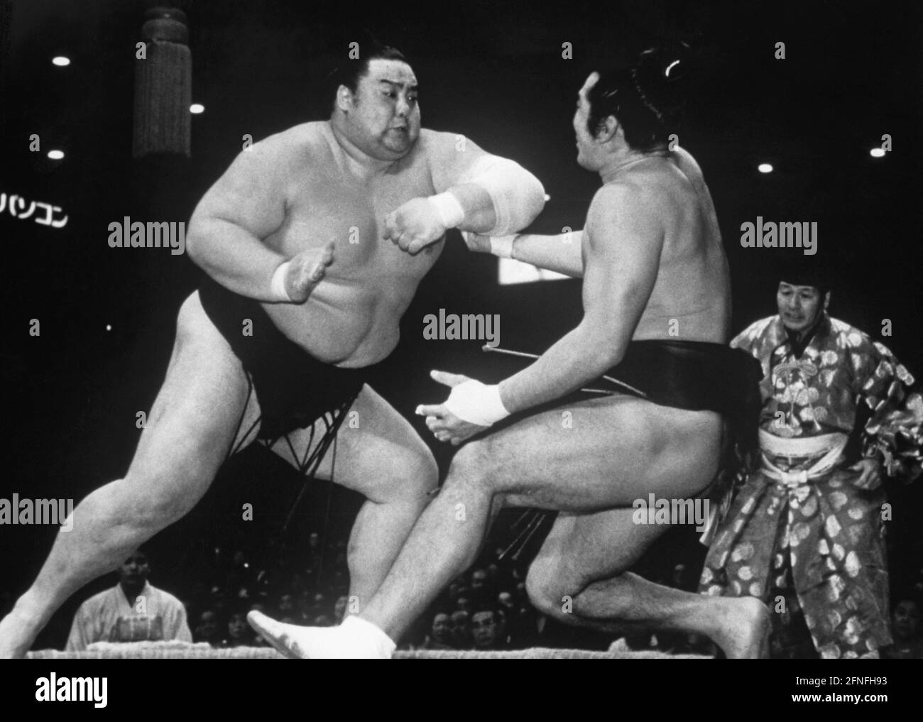 Szene während eines Sumo-Spiels in Osaka. Einer der beiden Kämpfer hat seinen Gegner aus dem Gleichgewicht gebracht. Neben den beiden ist der Gyoji, einer der Richter. [Automatisierte Übersetzung] Stockfoto