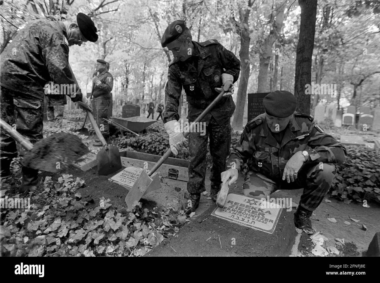 Aktion der Bundeswehr auf dem Jüdischen Friedhof in Berlin - Weissensee, nachdem kurz zuvor mehr als hundert Gräber zerstört worden waren, werden sie von Soldaten restauriert, mit Grabstein und Efeu-Hügel, DEU, Berlin-Weissensee, 26.10.1999, Stockfoto