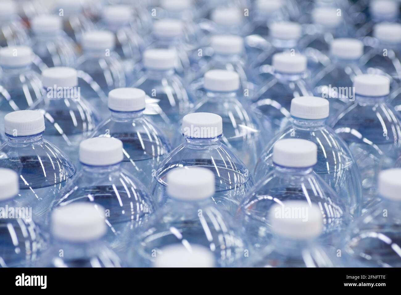 Wasserflaschen im Supermarkt. Pakete mit sauberem Trinkwasser in Plastikflaschen auf der Theke des Ladens. Hochwertige Fotos Stockfoto