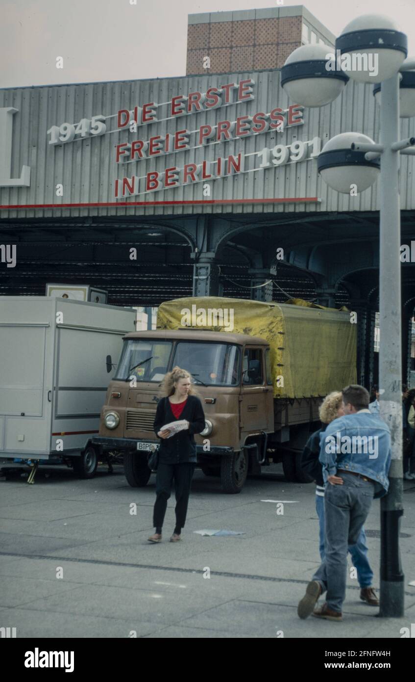 '''1945 die erste freie Presse in Berlin 1991'', Tagesspiegel Werbeslogan auf einer Brücke in Mitte, Ost-Berlin, DDR. Davor ein Paar und eine Frau auf einem Platz. Fotografie um 1991 [automatisierte Übersetzung]' Stockfoto