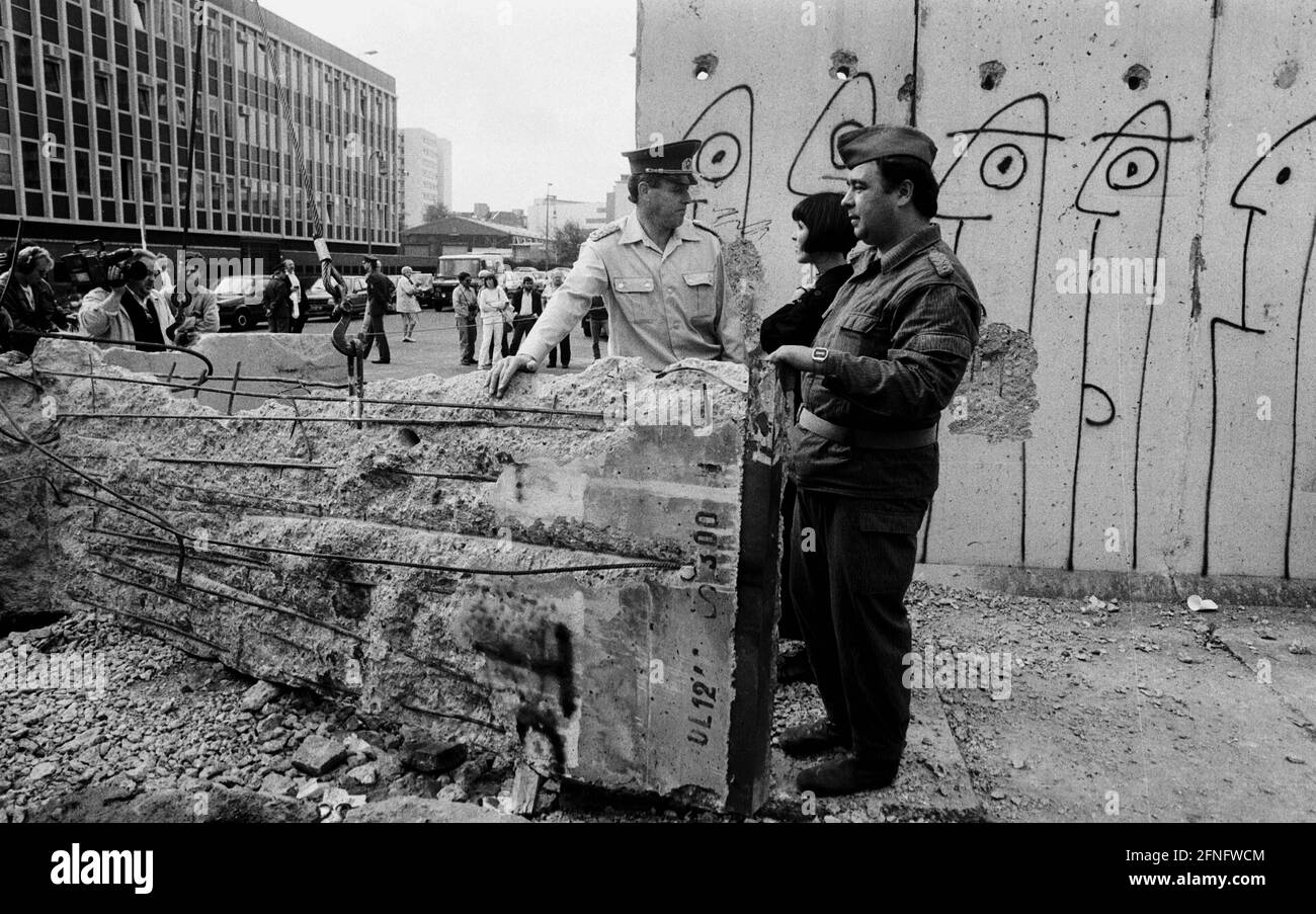 Berlin-Bezirke / DDR-Mauer / 1990 Kreuzberg: DDR-Grenzposten reißen die Mauer in der Zimmerstraße nieder. Es ist ihr letzter Job. Danach sind sie arbeitslos. // Vereinigung / DDR / Geschichte / Kommunismus / [automatisierte Übersetzung] Stockfoto