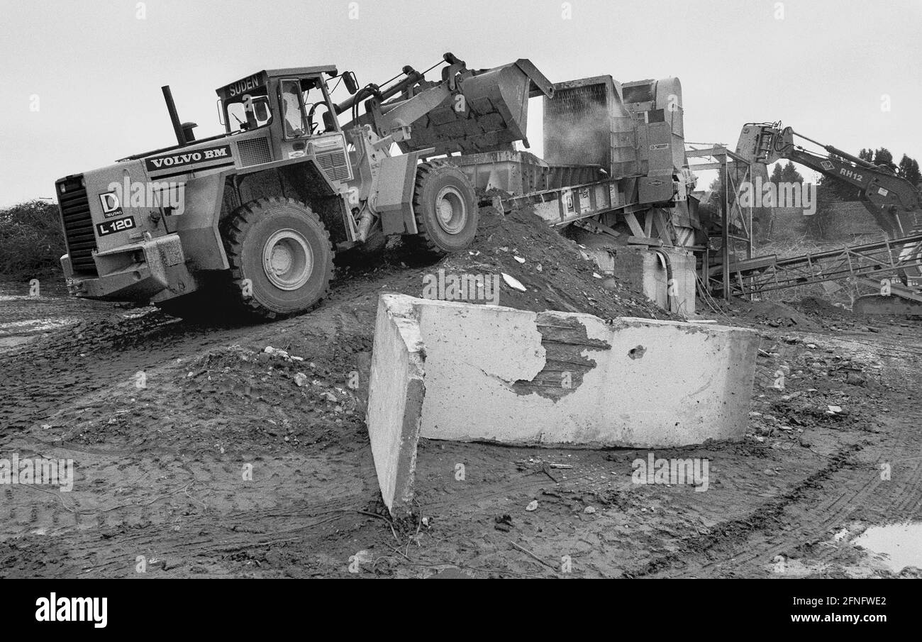 Berlin / / DDR / Mauer / 1991 Ende der Mauer, Ende der DDR. Hochzeit: In der Graunstraße wurde ein Recyclingplatz für die Mauerreste eingerichtet. Die L-förmigen Elemente werden zerkleinert und als Baustoff wiederverwendet. Andere farbig lackierte Elemente werden verkauft oder verschenkt. 3 von ihnen stehen also vor der UNO in New York. // Vereinigung / Vereinigung / Bezirke / Prenzlauer Berg Geschichte / Kommunismus / Mauerende [automatisierte Übersetzung] Stockfoto