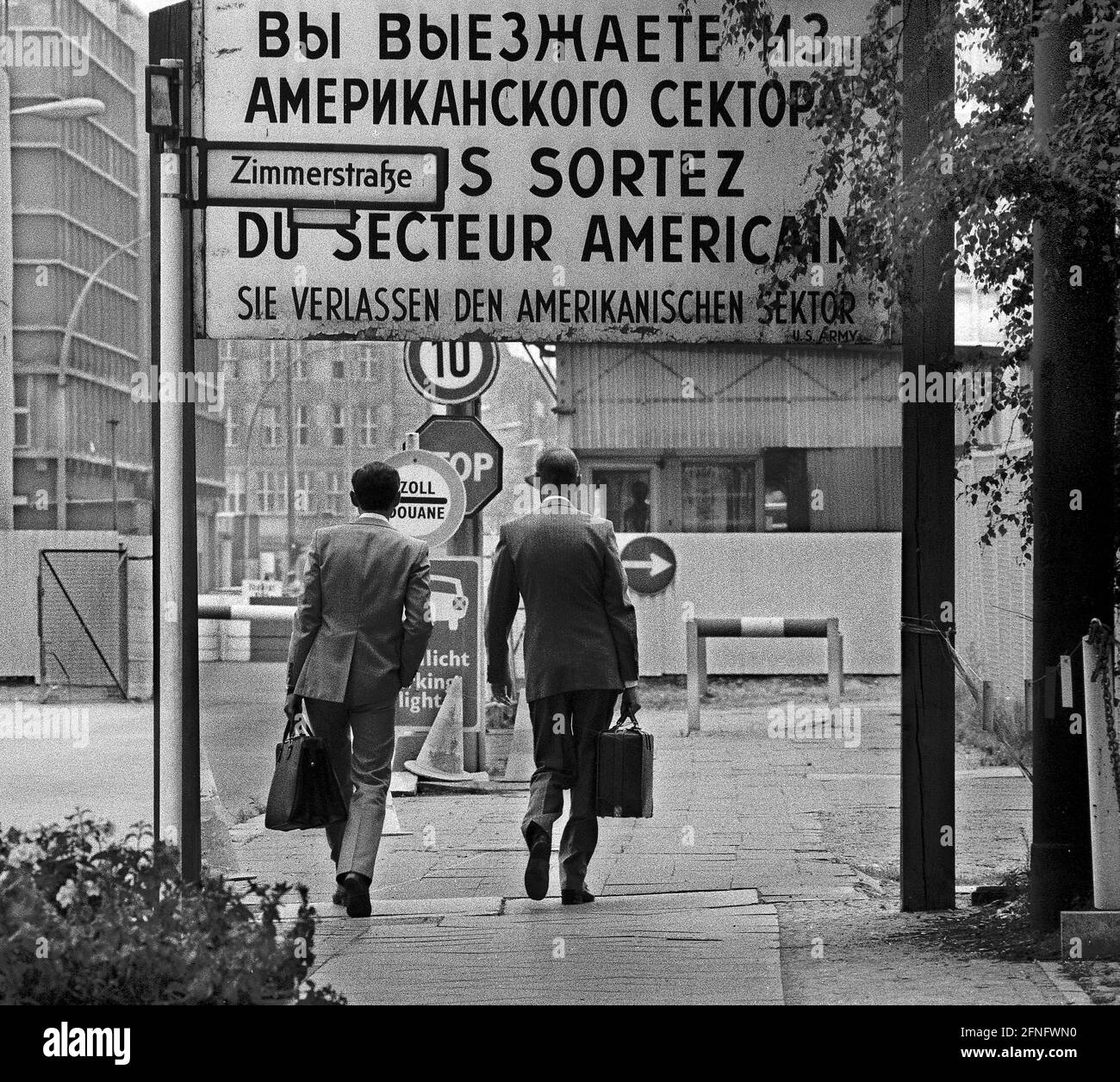 Berlin-Stadtteile / DDR-Mauer / 1.7.1981 Checkpoint Charly. Der Grenzübergang zwischen Kreuzberg und Mitte ist für Ausländer, darunter Diplomaten, reserviert. Sie werden vom deutschen Zoll, einem Hilfsorgan der Westalliierten, abgeräumt. Zwei Geschäftsleute gehen nach Ost-Berlin. Am Checkpoint Charly standen sich amerikanische und sowjetische Panzer während des Mauerbaus 1961 gegenüber. Viersprachiges Zeichen der 4 Alliierten: Sie verlassen den amerikanischen Sektor // Berliner Status / Checkpoint / Grenze / Bezirke / // Geschichte / Alliierten / Kommunismus / Sowjets [automatisierte Übersetzung] Stockfoto