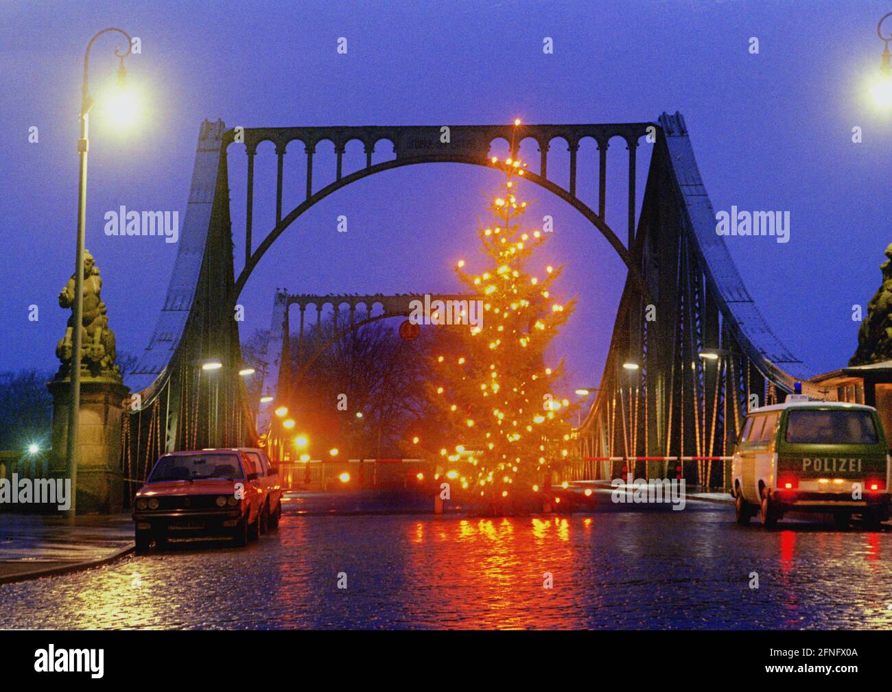 Berlin-Bezirke / Zehlendorf / Potsdam / DDR / 1987 Glienicker Brücke. Wie jedes Jahr hat der Berliner Senat einen Weihnachtsbaum vor die geschlossene Brücke gestellt. Nur das Militär der vier Verbündeten darf vorbeikommen, manchmal auch Spione. Rechts das viersprachige Zeichen: Sie verlassen den amerikanischen Sektor // Weihnachten / Mauer / Kalter Krieg / DDR-Mauer / Geschichte / Kommunismus / Feste / Alliierten [automatisierte Übersetzung] Stockfoto