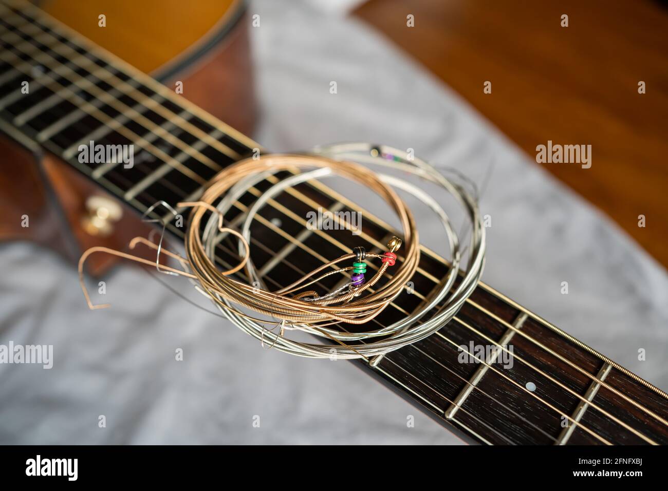 Alte Stahlgitarrensaiten auf akustischem Gitarrenhals Stockfoto