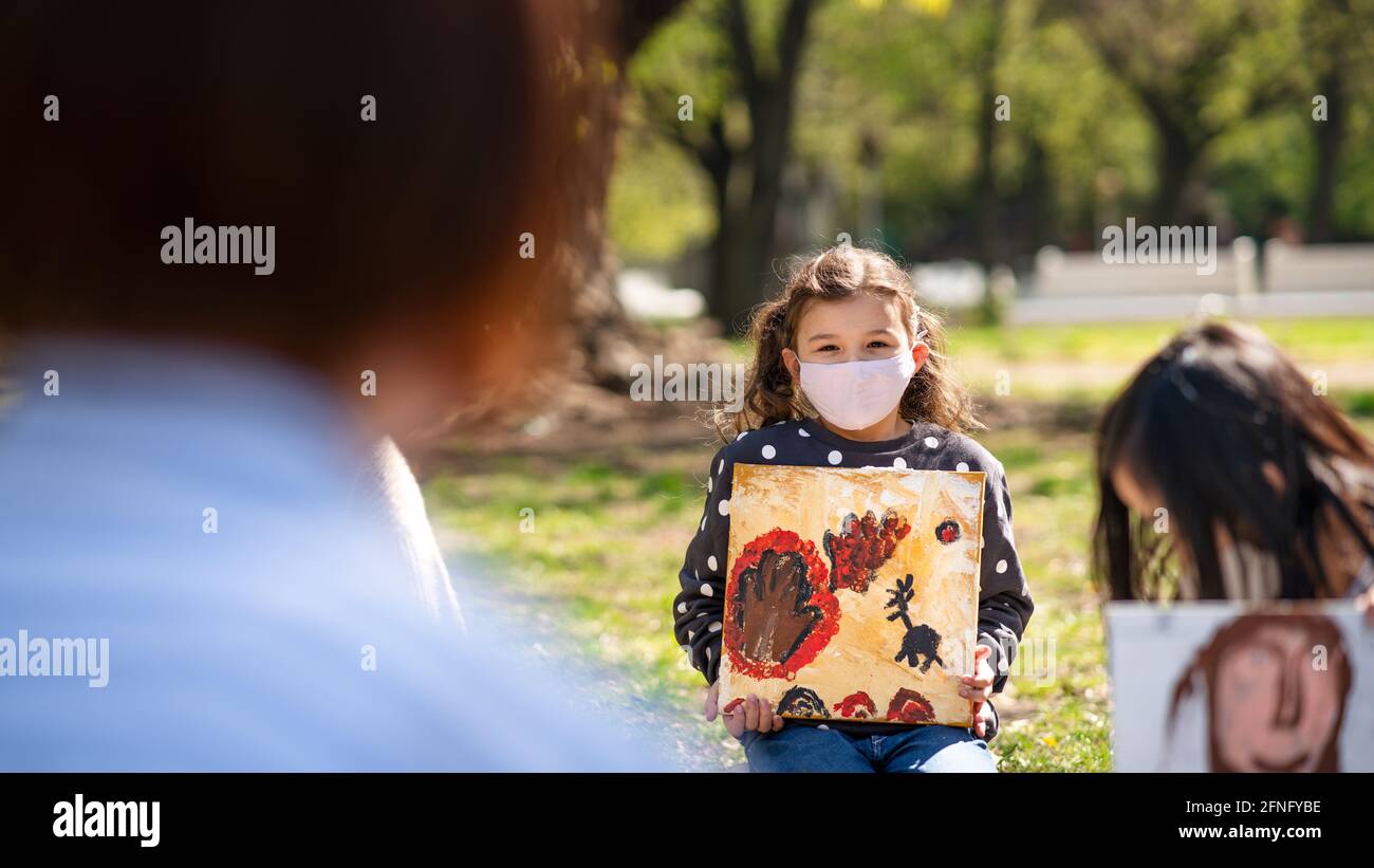 Kleine Kinder mit Lehrer im Freien im Stadtpark, Lerngruppe Bildung und Coronavirus-Konzept. Stockfoto