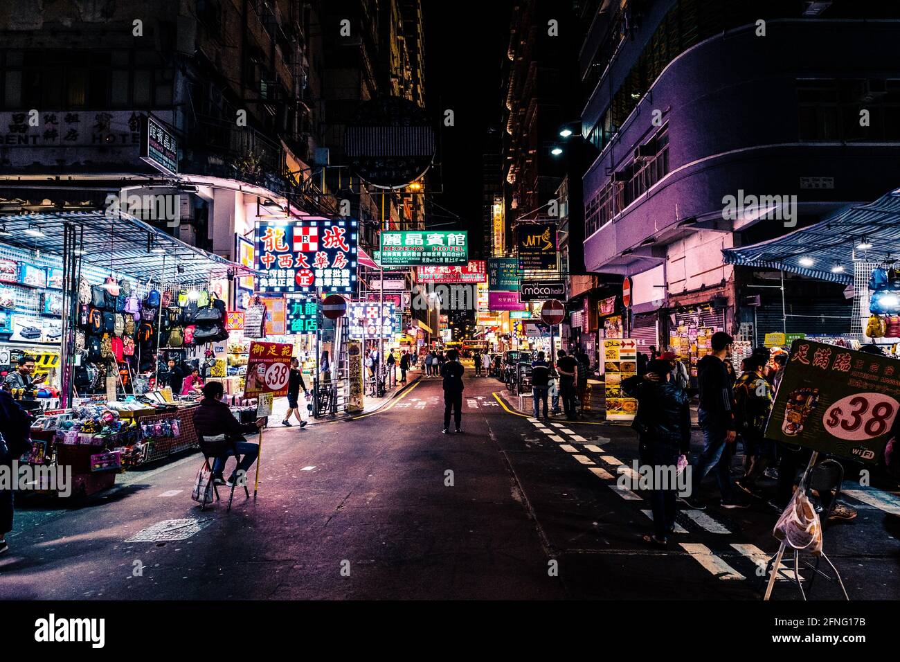 Hongkong - November 2019: Beleuchtete Geschäfte und Menschen auf der Straße bei Nacht in HongKong City, Mongkok Stockfoto