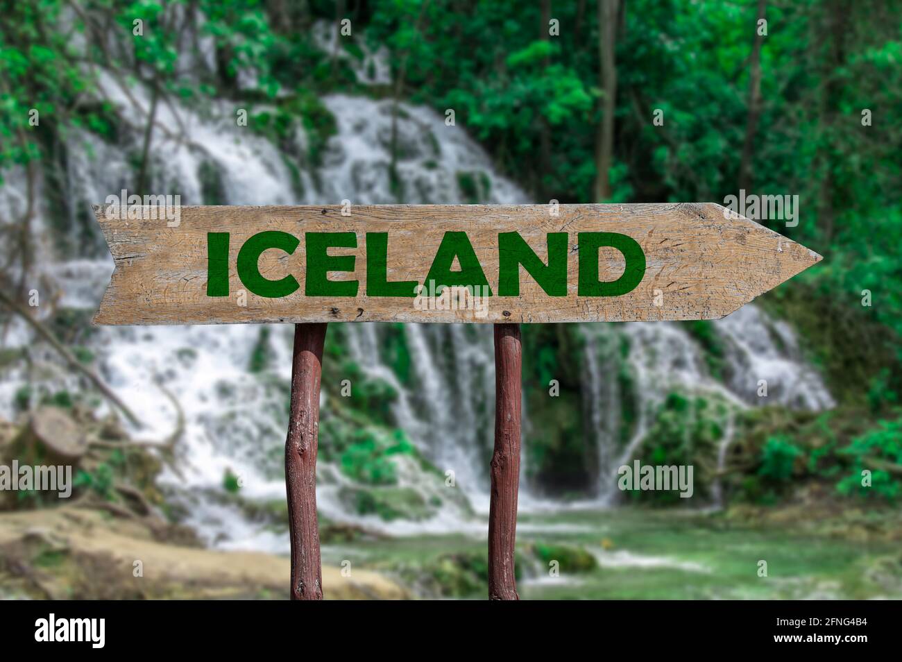 Island Holzpfeil Straßenschild gegen Wald Wasserfall Kaskade. Reise nach Island Konzept. Stockfoto