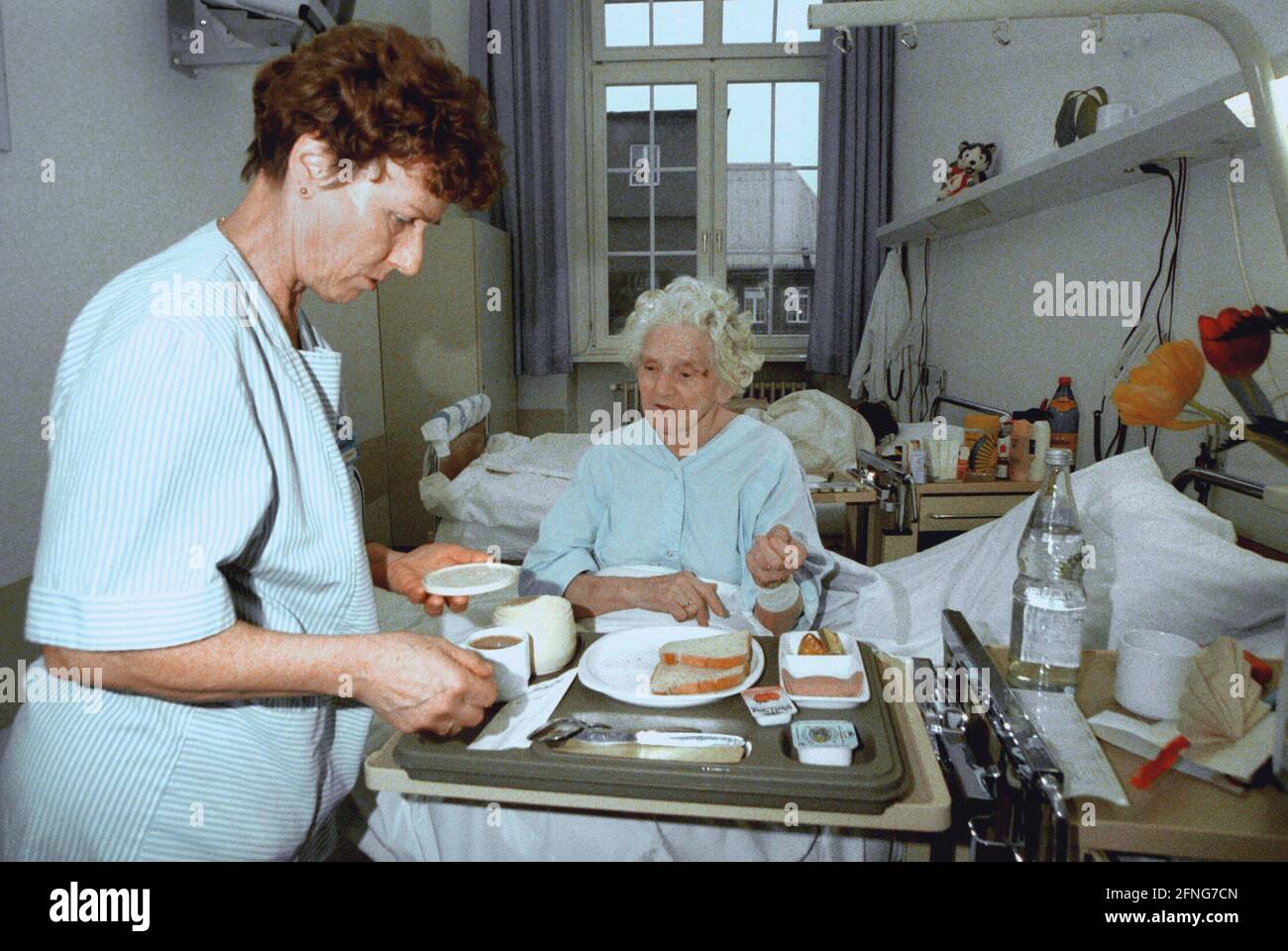 Berlin / Gesundheit / Krankenhaus / 1997 Krankenhaus Prenzlauer Berg, interne Abteilung. Krankenschwester bringt Frühstück, alte Patientin // alte Menschen / Senioren / Frauen arbeiten / [automatisierte Übersetzung] Stockfoto