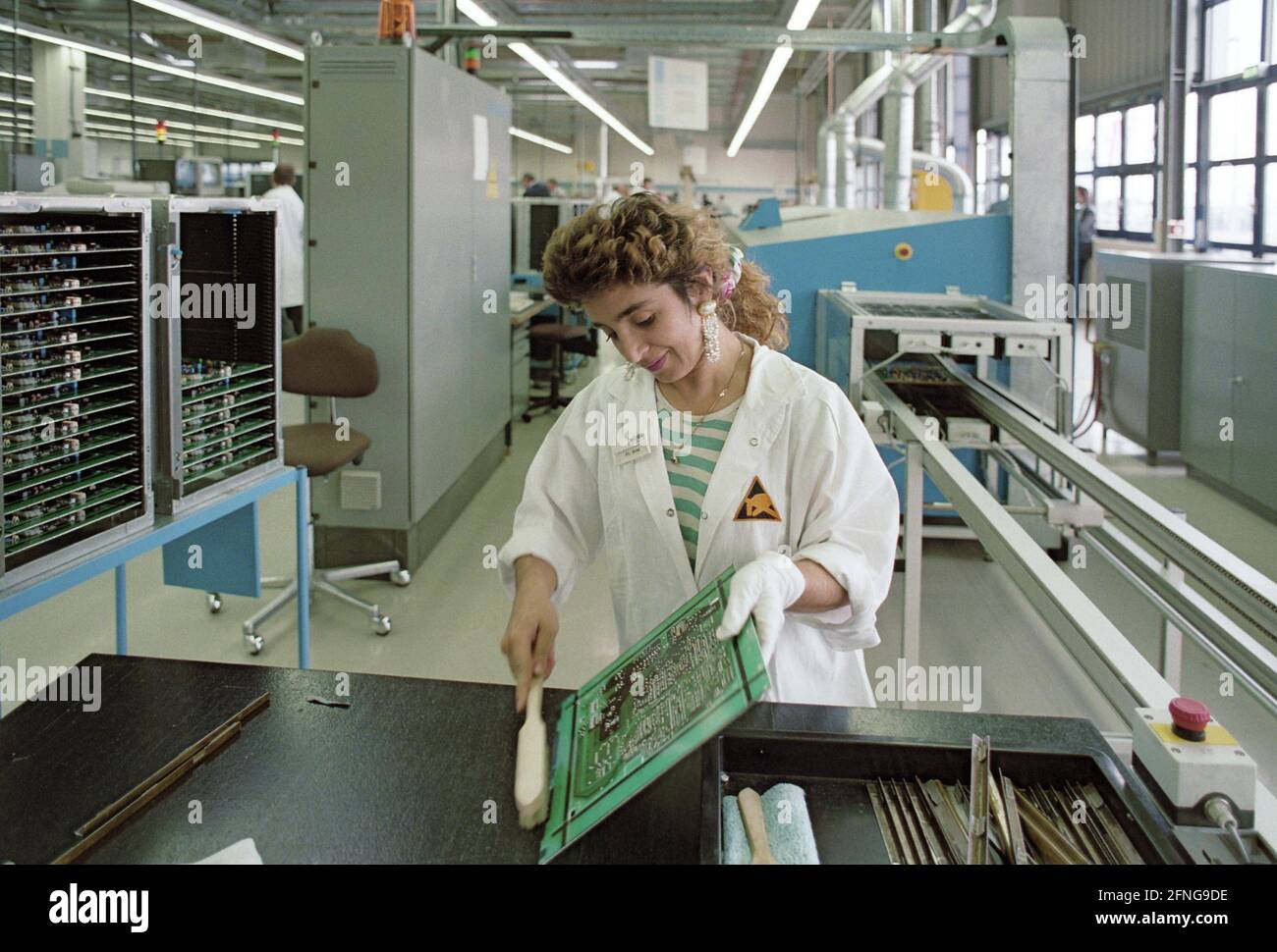 Berlin-Brandenburg / Industrie / Ausländer / 8/1993 Türkische Mitarbeiterin bei DeTeWe im Werk Hoppegarten bei Berlin. In der Fabrik werden Komponenten der digitalen Börsen der Telekom hergestellt. Die Produktion erfolgt fast vollautomatisch (siehe Fotos 1980, viel Handarbeit). Diese Frau mit Kopftuch steckt Leiterplatten ein // Turks / Arbeit / Elektronik [automatisierte Übersetzung] Stockfoto