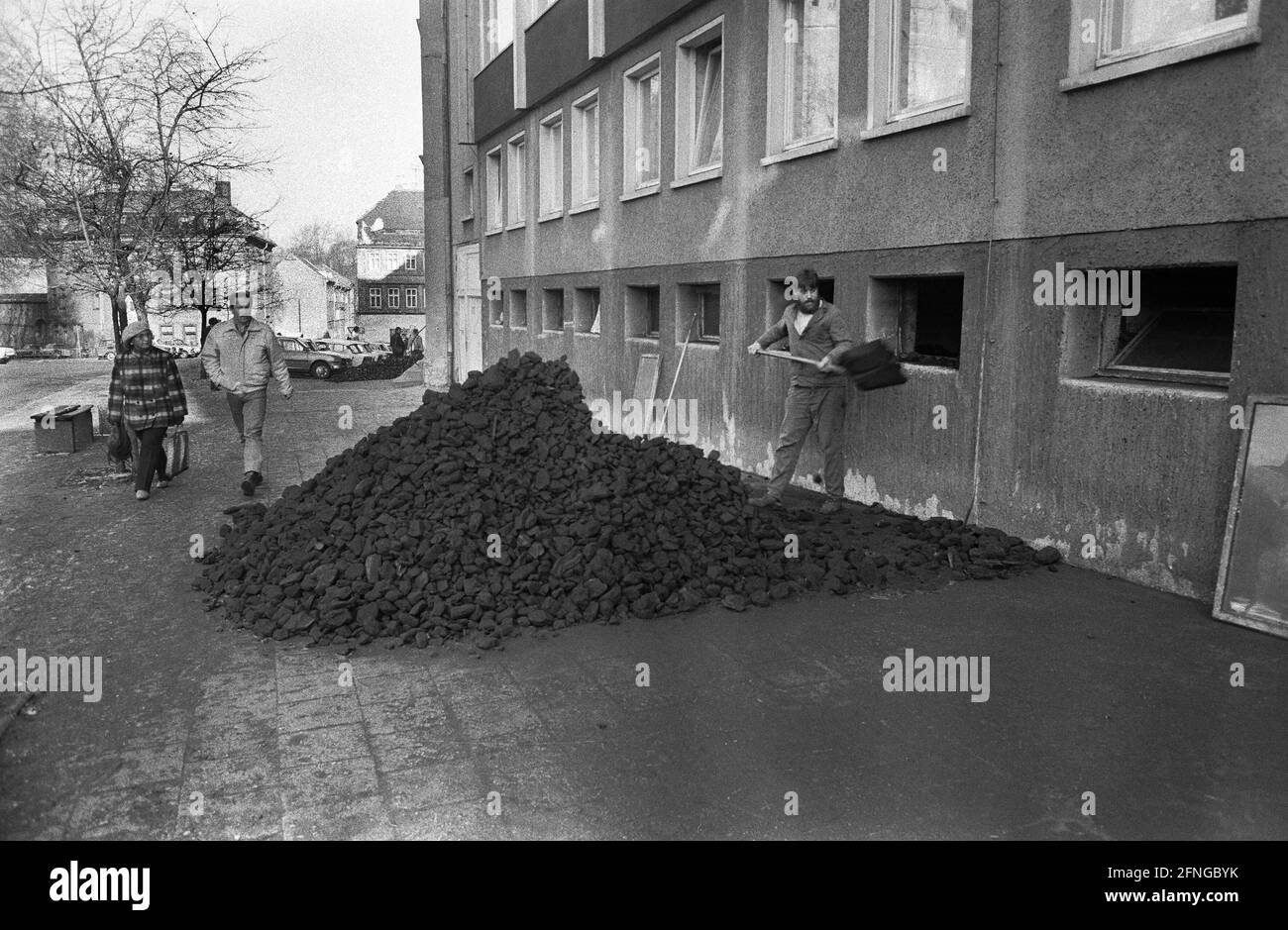 Deutschland, Bautzen, 06.01.1990. Archiv Nr.: 12-11-23 die Altstadt von Bautzen erstreckt sich auf dem Felsplateau oberhalb der Spree, dessen Spitze die Ortenburg bildet. Es wird von der Stadtmauer begrenzt. Die später erbauten neueren Teile im Osten der Stadt sind von der Stadtmauer umschlossen. Foto: Junger Mann schaufelt Kohle in ein Haus [automatisierte Übersetzung] Stockfoto