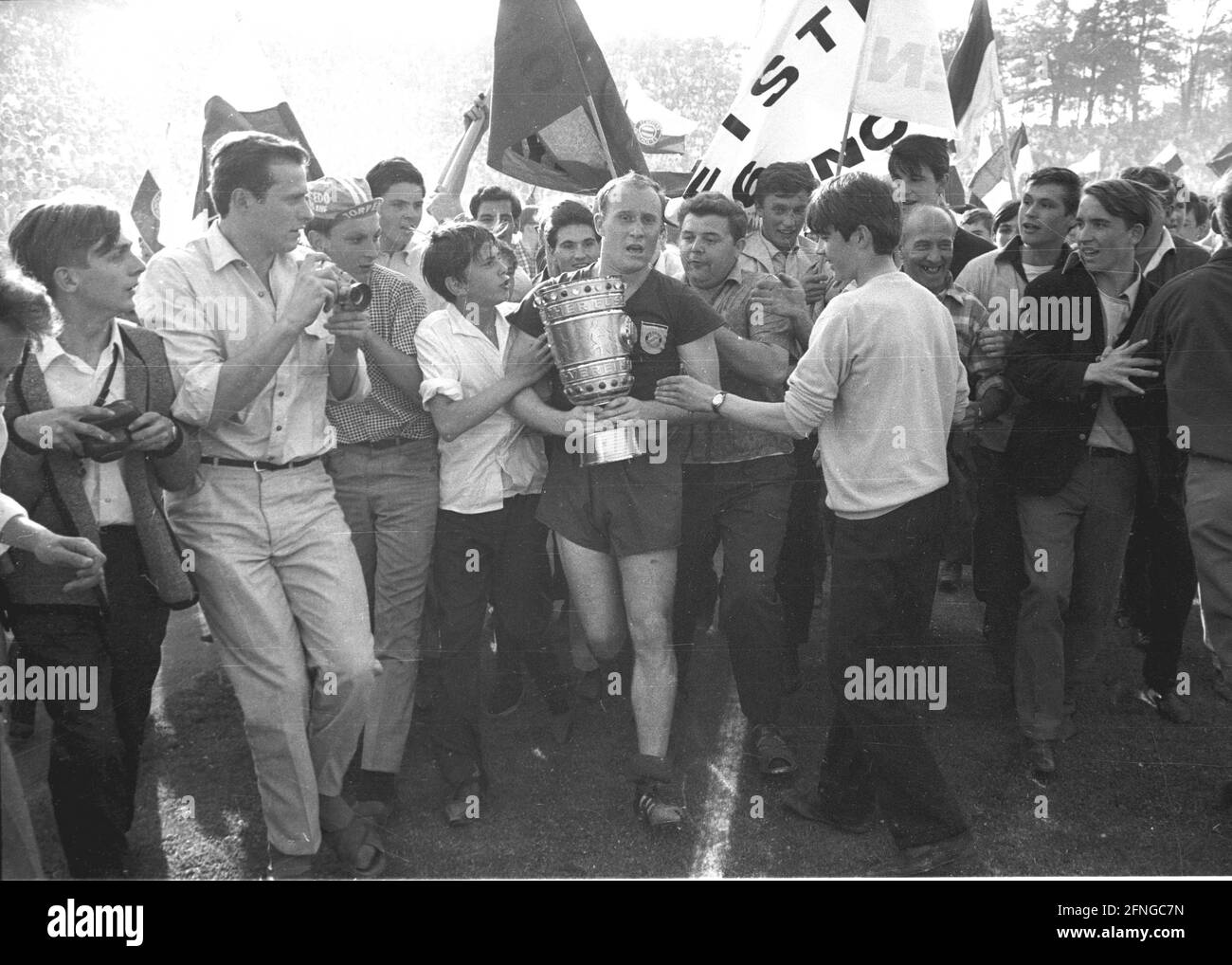 DFB-Pokalfinale FC Bayern München - MSV Duisburg 4:2 /04.06.1966/ DFB-Pokalsieger FC Bayern Dieter Brenninger (FC Bayern) mit dem Pokal, umgeben von Bayern-Fans, die auf das Spielfeld rannten. [Automatisierte Übersetzung] Stockfoto