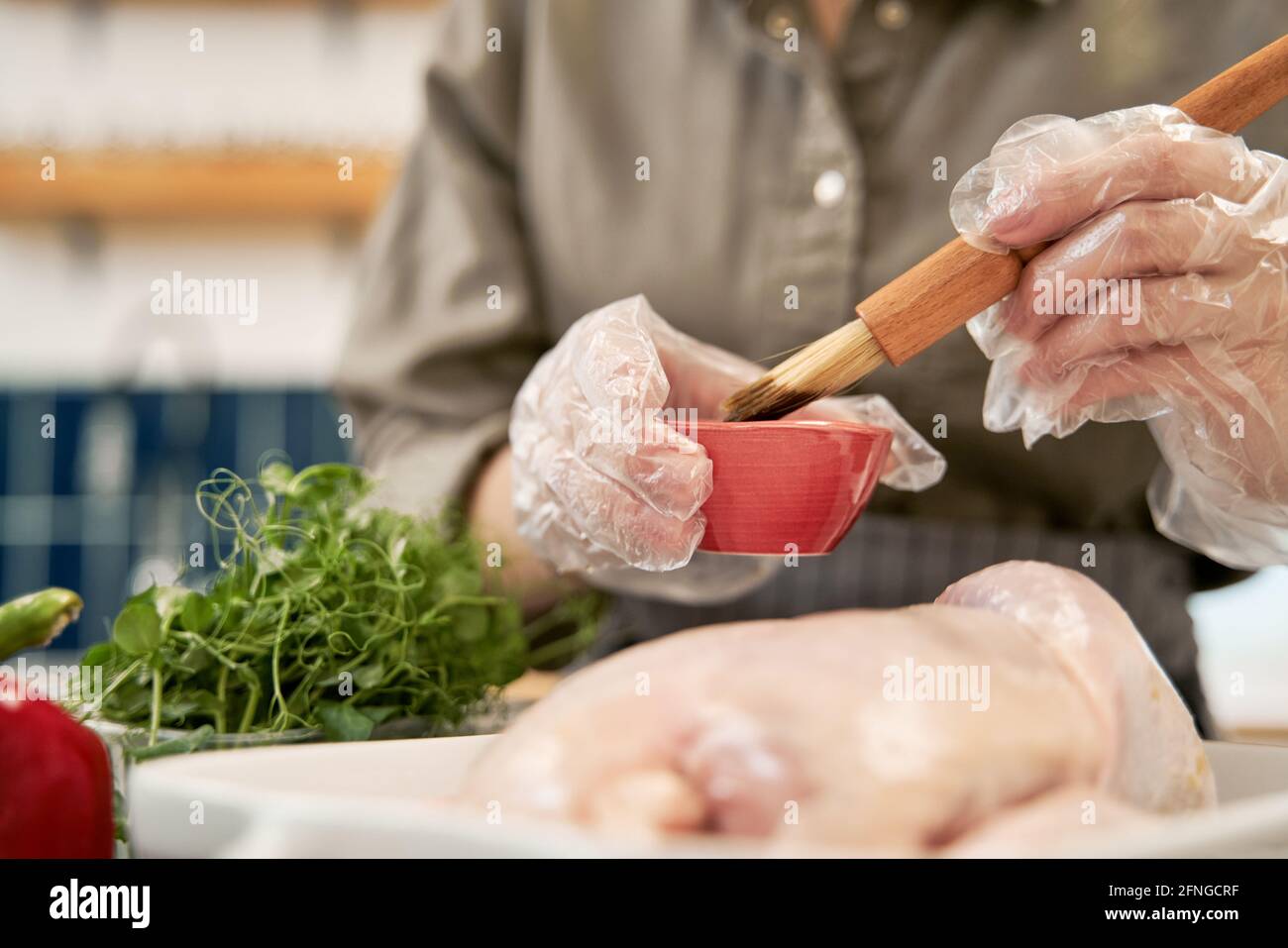 Anonyme verschwommene Frau, die Glas berührt, während sie im dunklen Raum steht Mit orangefarbener Beleuchtung Stockfoto