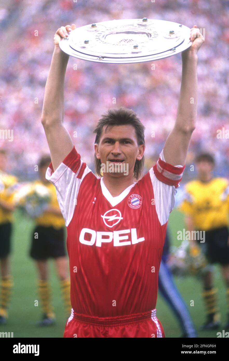 FC Bayern München Deutscher Meister 1990. 12.05.1990. Teamkapitän Klaus Augenthaler überreicht die Meisterschaftspokal. [Automatisierte Übersetzung] Stockfoto