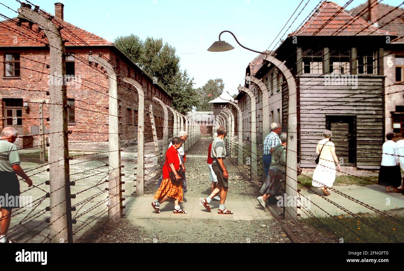 Polen / Geschichte / Konzentrationslager / 1999 Konzentrationslager Auschwitz, Hauptlager, Stacheldrahtzaun und Wachturm rechts // Juden / Nazis / Faschismus // UNESCO-Weltkulturerbe *** Ortsüberschrift *** Geschichte / Faschismus / Polen / Nationalsozialismus / Juden / Konzentrationslager Auschwitz (Alter Teil). Verbrennungsofen im Krematorium, Touristen bilden Rumänien // UNESCO-Weltkulturerbe / [automatisierte Übersetzung] Stockfoto