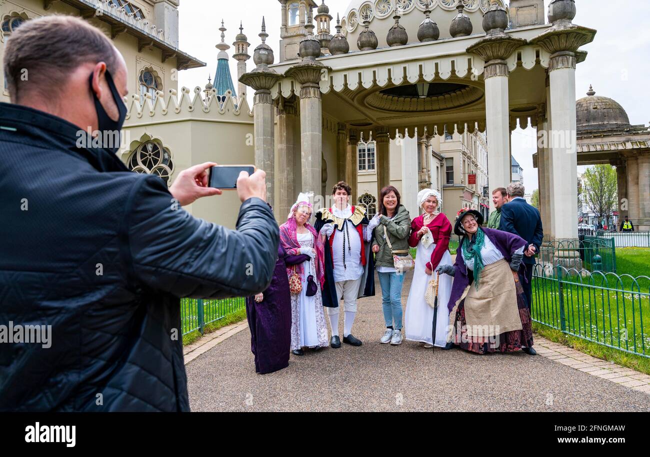 Brighton UK 17. Mai 2021 - Besucher posieren mit Mitarbeitern in Regency-Kostümen im Royal Pavilion in Brighton, der heute morgen wieder für die Öffentlichkeit geöffnet wurde, als die nächste Stufe der Sperrungsbeschränkungen heute in ganz England gelockert wurde : Credit Simon Dack / Alamy Live News Stockfoto
