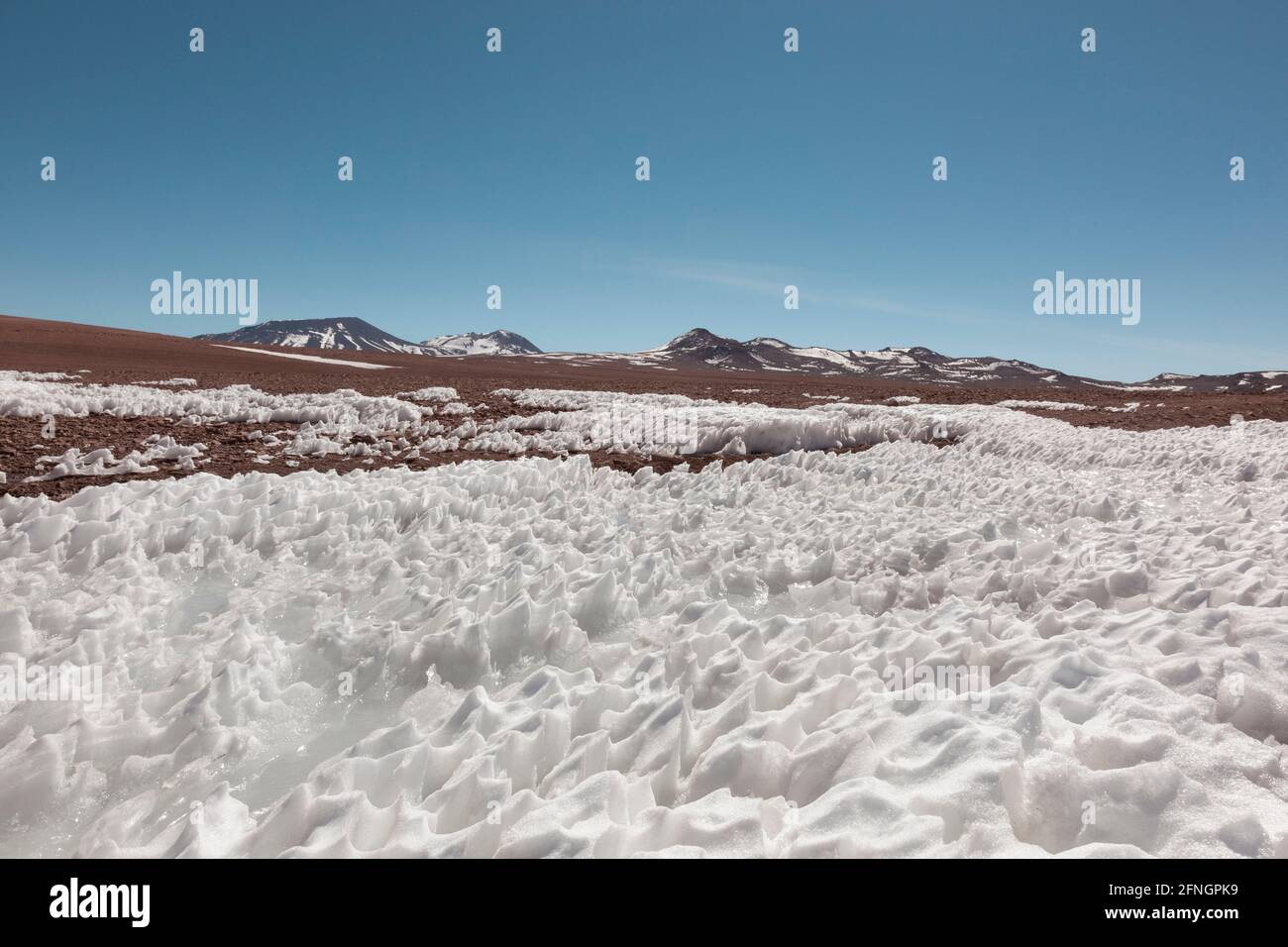 Der Wind hat Schnee auf dem Hochplateau in der bolivianischen Wüste geformt Stockfoto