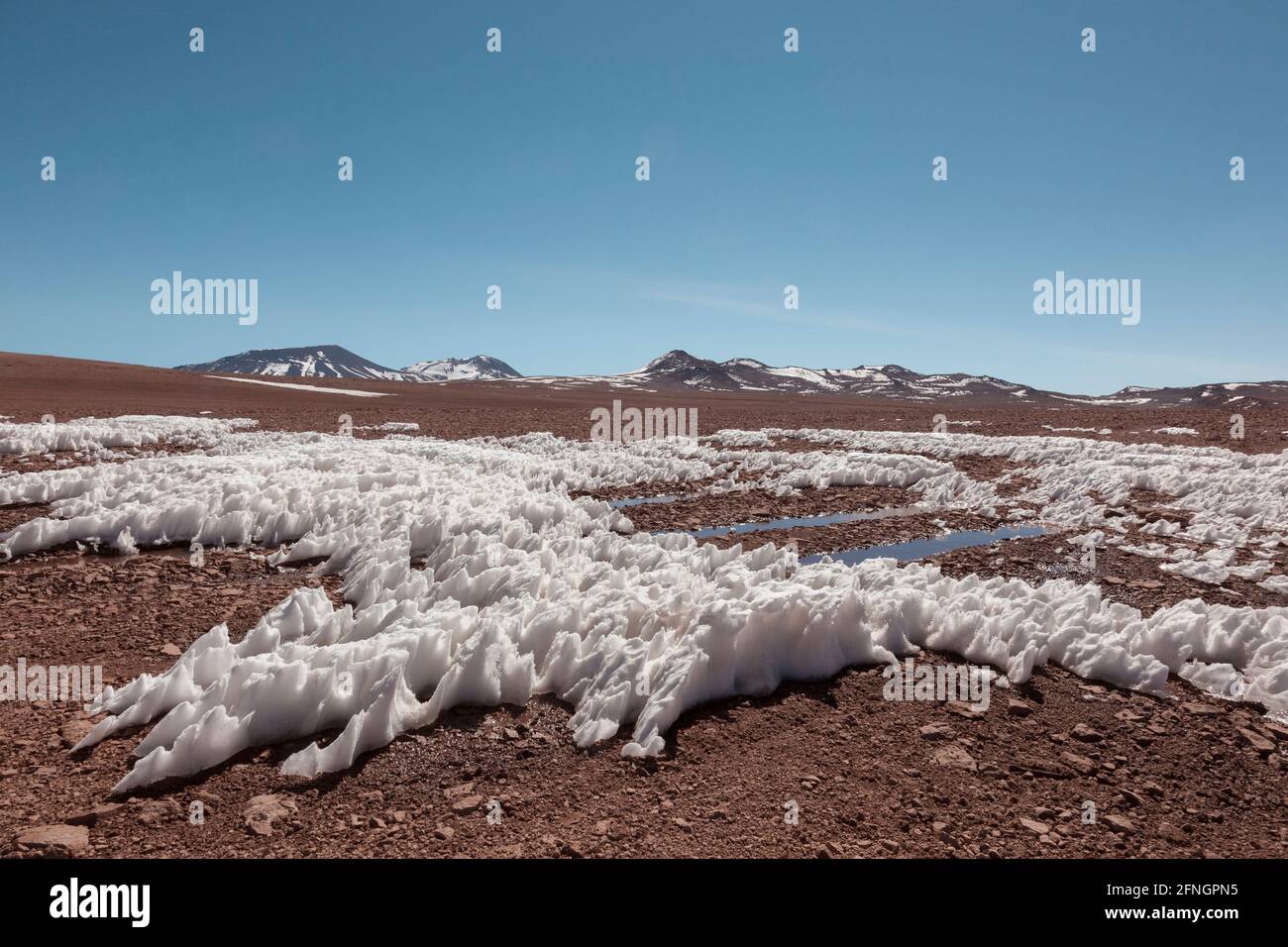 Der Wind hat Schnee auf dem Hochplateau in der bolivianischen Wüste geformt Stockfoto