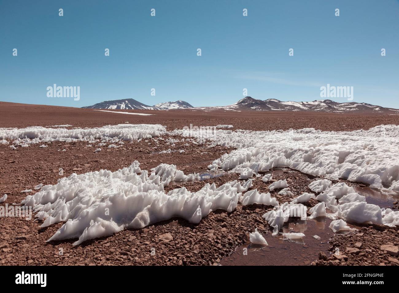 Der Wind hat Schnee auf dem Hochplateau in der bolivianischen Wüste geformt Stockfoto