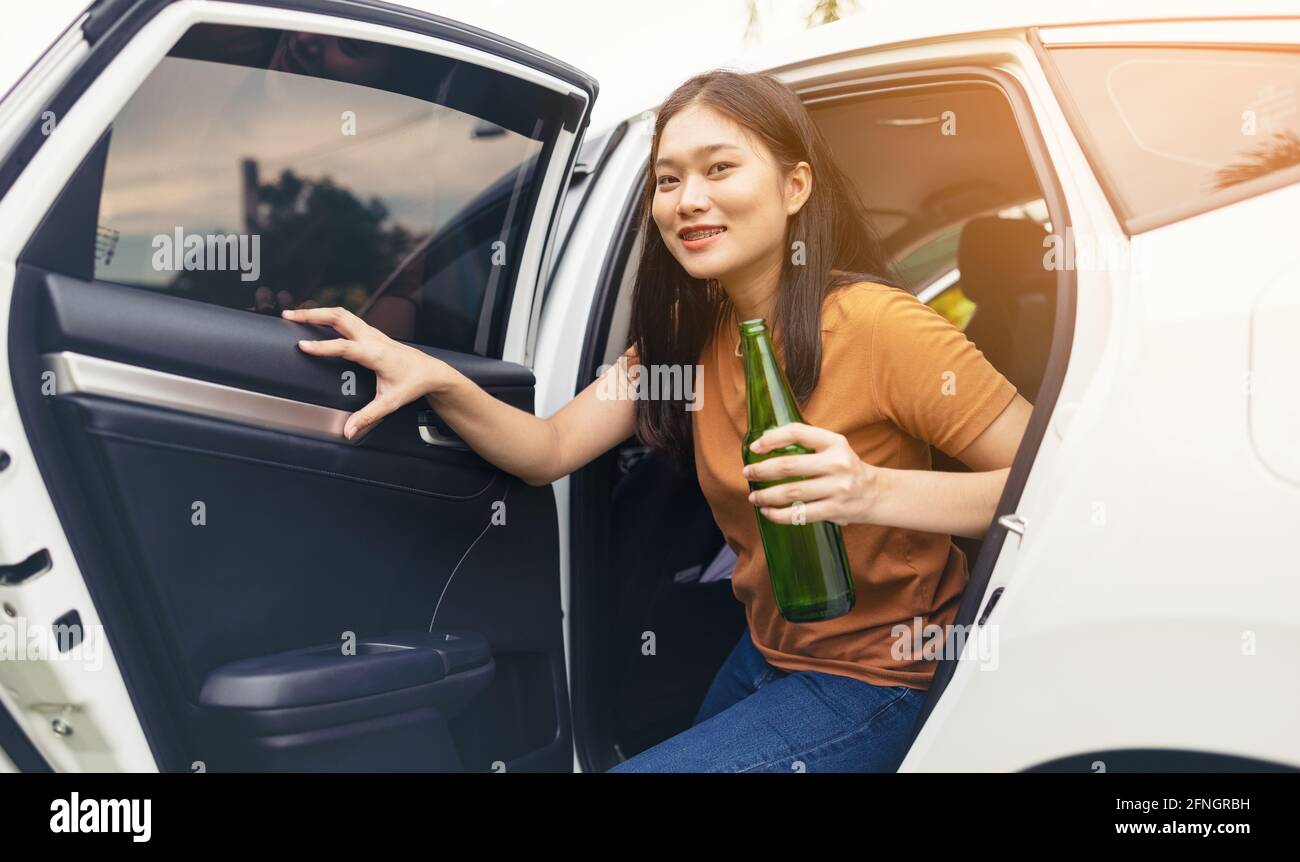 Trinken Sie ein Bier von Bottle im Auto, Mädchen trinken Alkohol Stockfoto
